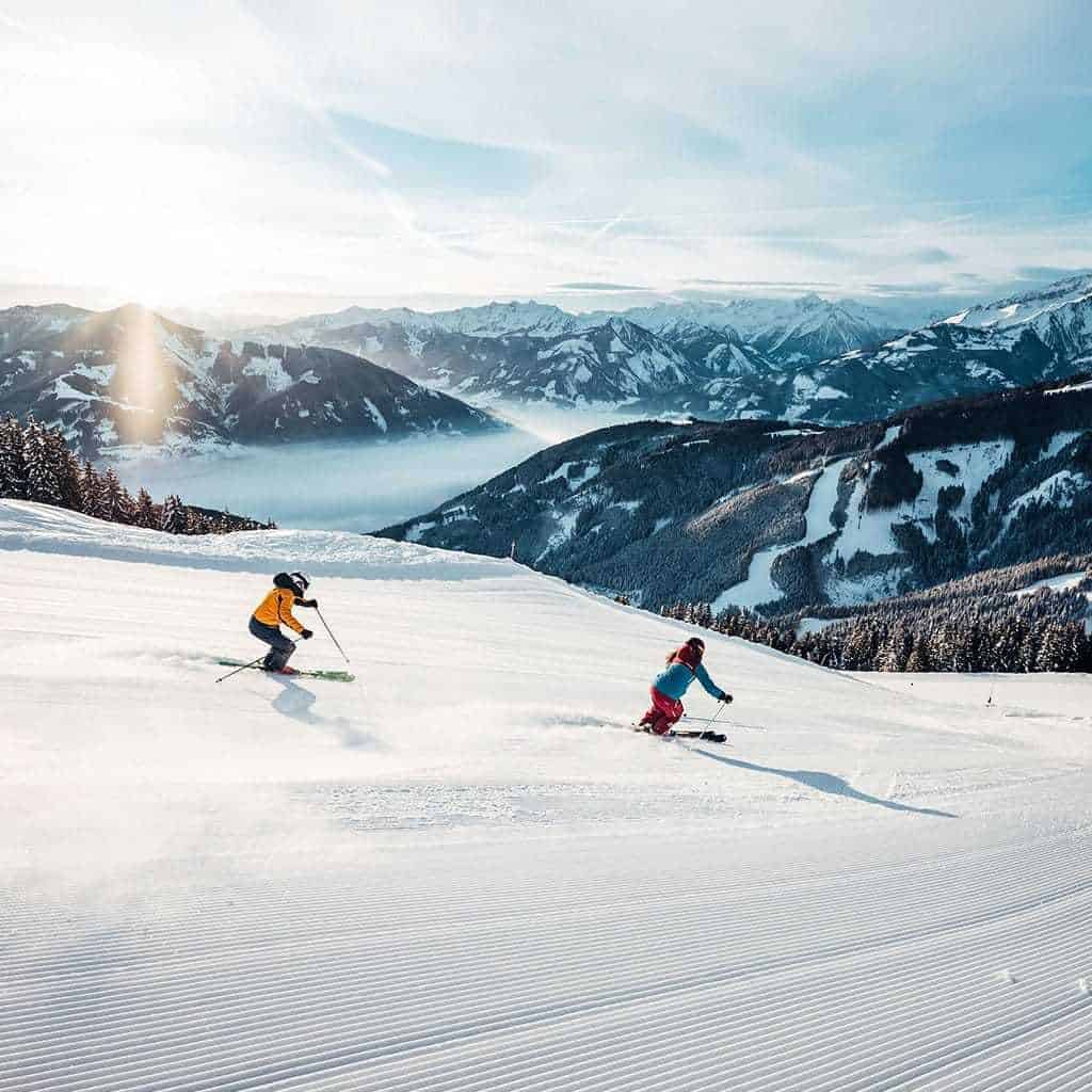 Skiurlaub in Zell am See: Zwei Skifahrer genießen die verschneite Berglandschaft.